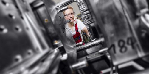 Arbeiter an einer Spritzgussmaschine in einem Industrieunternehmen in Hamburg.